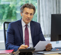 Bild vom Bürgermeister Andreas Zimmermann, sitzend mit einem Zettel in der Hand