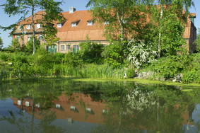 Bürgerhaus mit einem kleine Teich davor, bei sonnigem Wetter