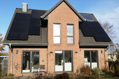 Bild mit Haus, dass Solarpanelen auf dem Dach angebracht hat